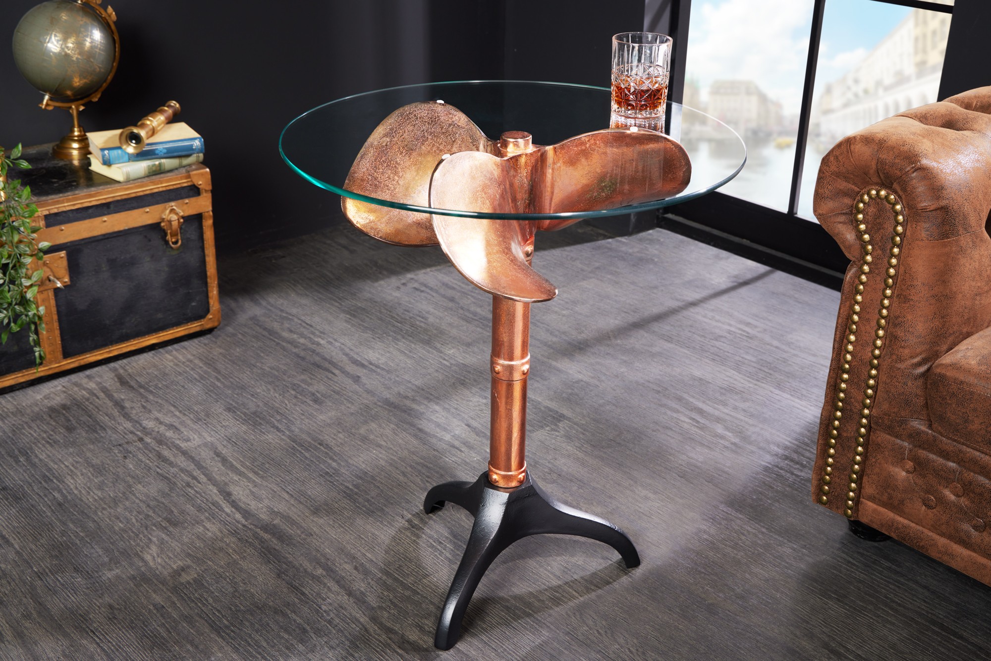 Estila Koloniálny okrúhly príručný stolík Helice s nohou v medenej farbe s dizajnom lodnej skrutky a sklenenou vrchnou doskou 73 cm